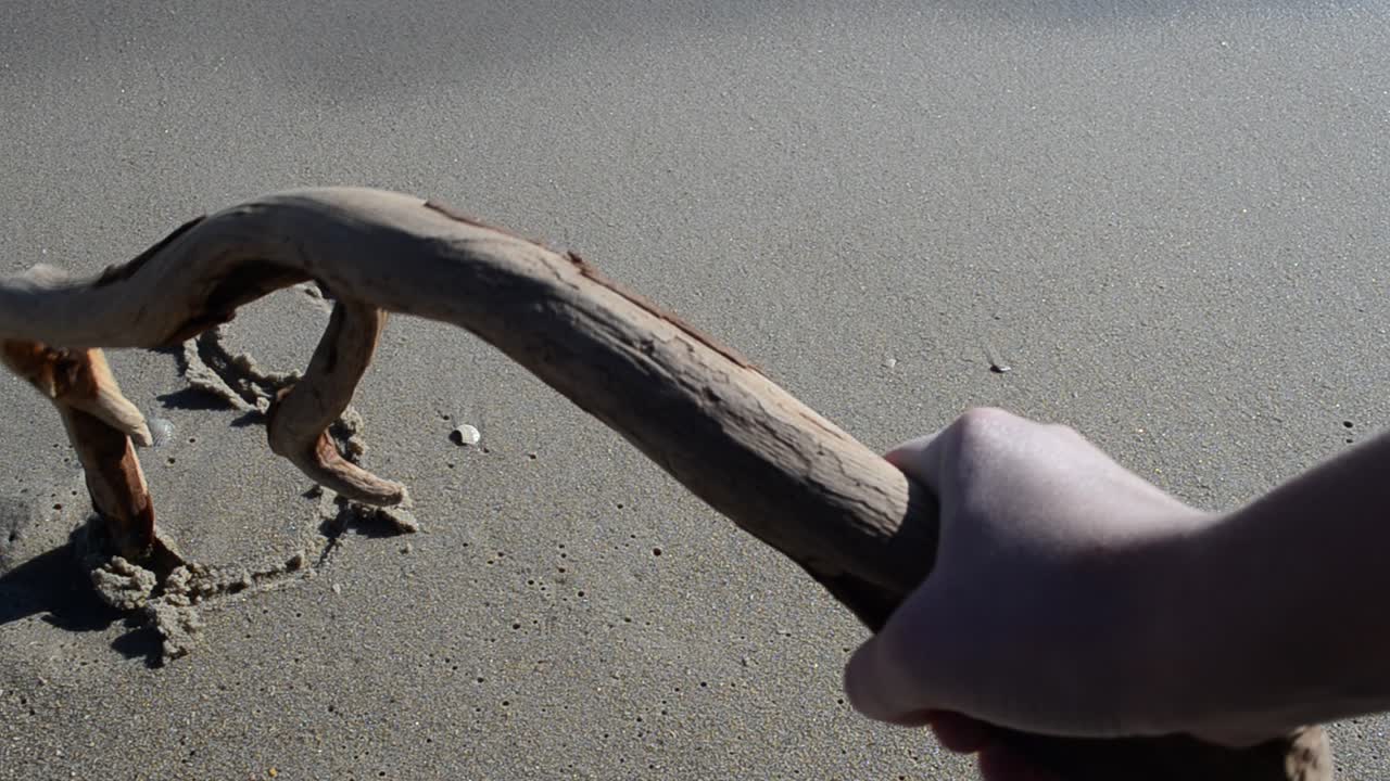 Indskriften SOS i sandet. Optagelse på stranden.