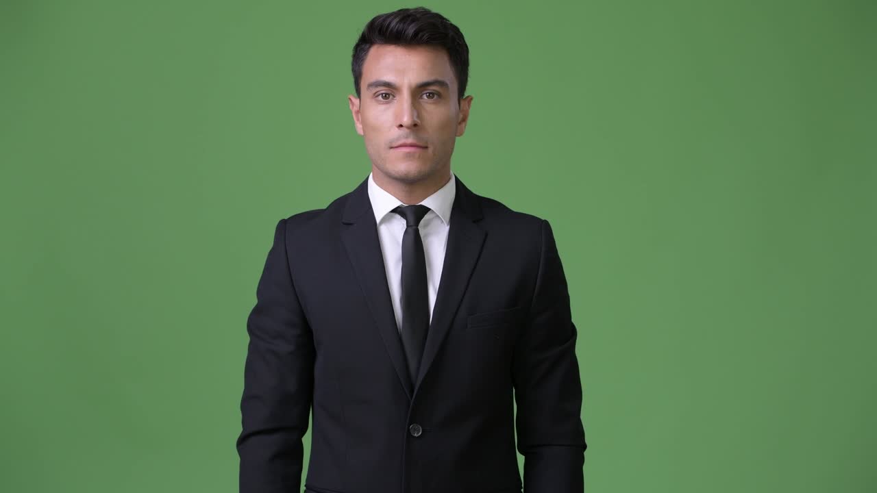 초록색 배경에 젊은 잘생긴 히스패닉 사업가