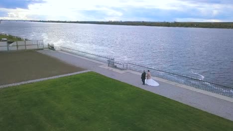 couple walking along a river during their wedding ceremony