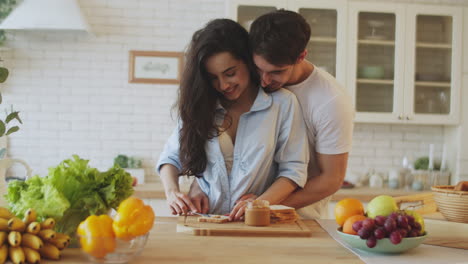 una pareja feliz cocinando el desayuno en casa.