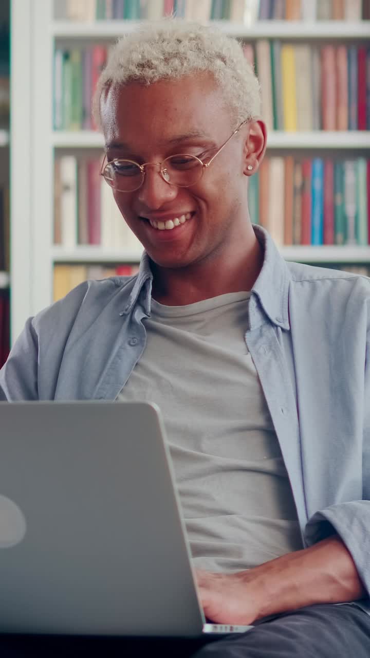 Young laughing positive african american man millennial watches comedy on laptop