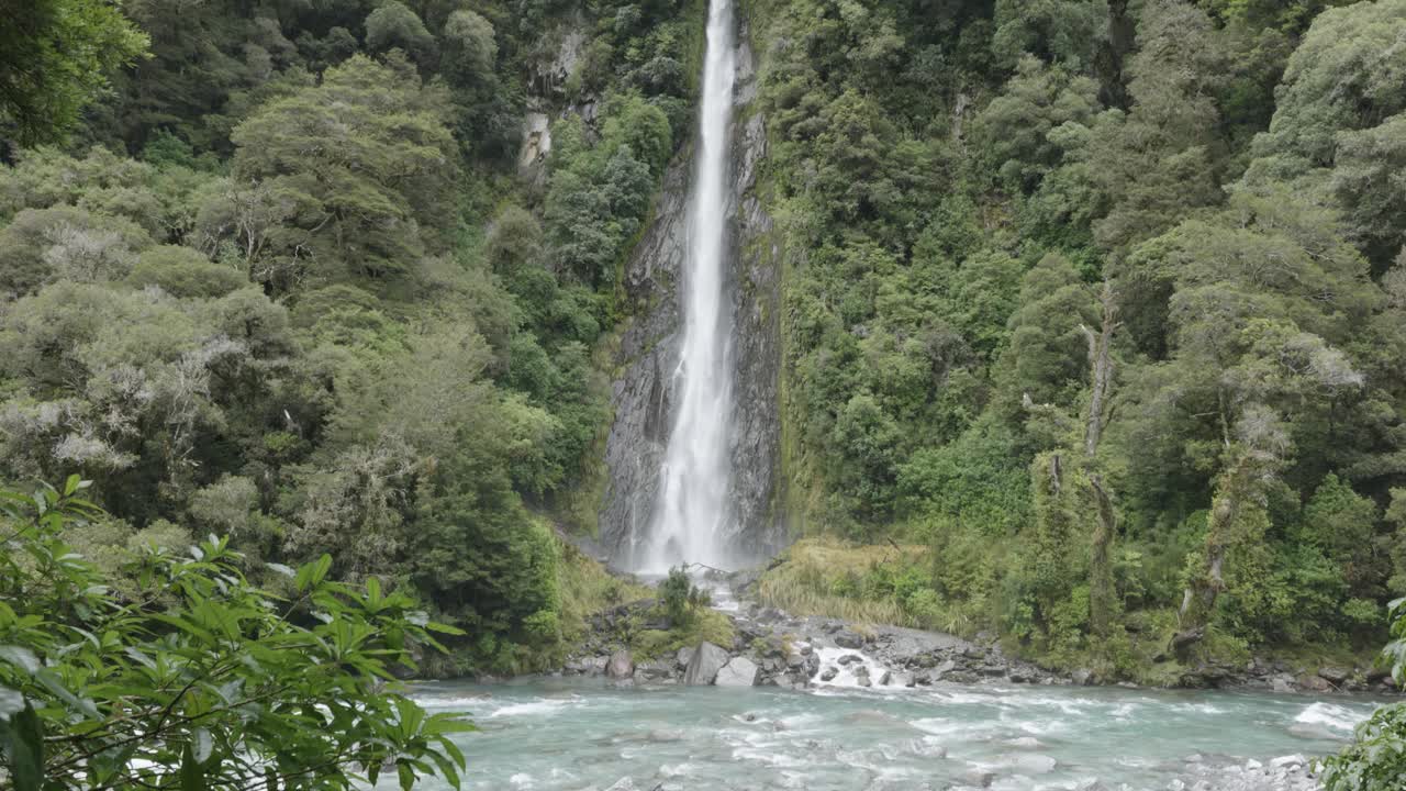 catarata alta entre un bosque en las cataratas de thunder creek, costa oeste, nueva zelanda