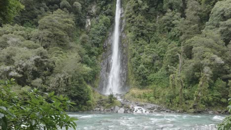 High-waterfall-in-between-a-forest-at-Thunder-Creek-Falls,-West-Coast,-New-Zealand