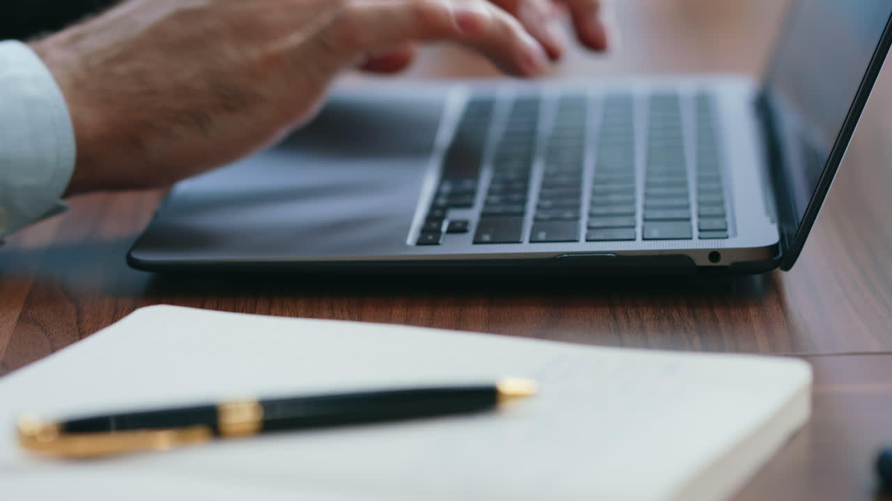 Businessman hands texting laptop making notes in notebook close up. Man typing