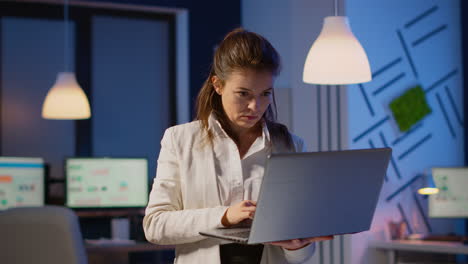 mujer de negocios enfocada comprobando los informes de la compañía de pie en la oficina de inicio