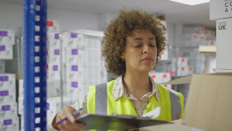 Female-Worker-In-Logistics-Distribution-Warehouse-Checking-Stock-Using-Digital-Tablet