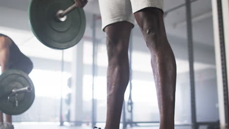 lifting barbell, man working out in gym, focusing on strength training