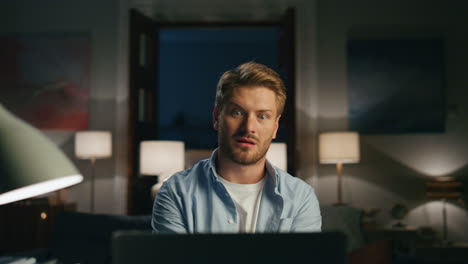 confused man videocalling apartments closeup. surprised guy talking online