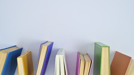 libros vintage de tapa dura en colores vibrantes se mueven en la mesa. lat lay stop motion