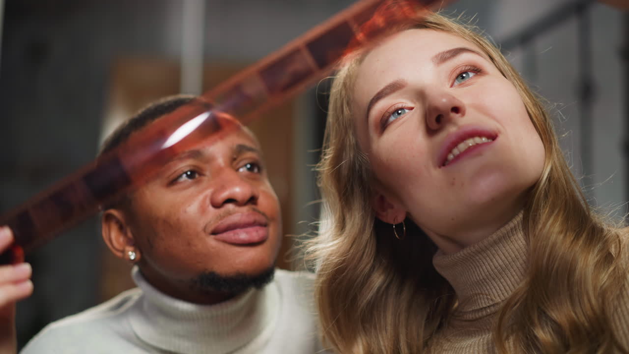 una pareja feliz mira una película a color procesada en el estudio