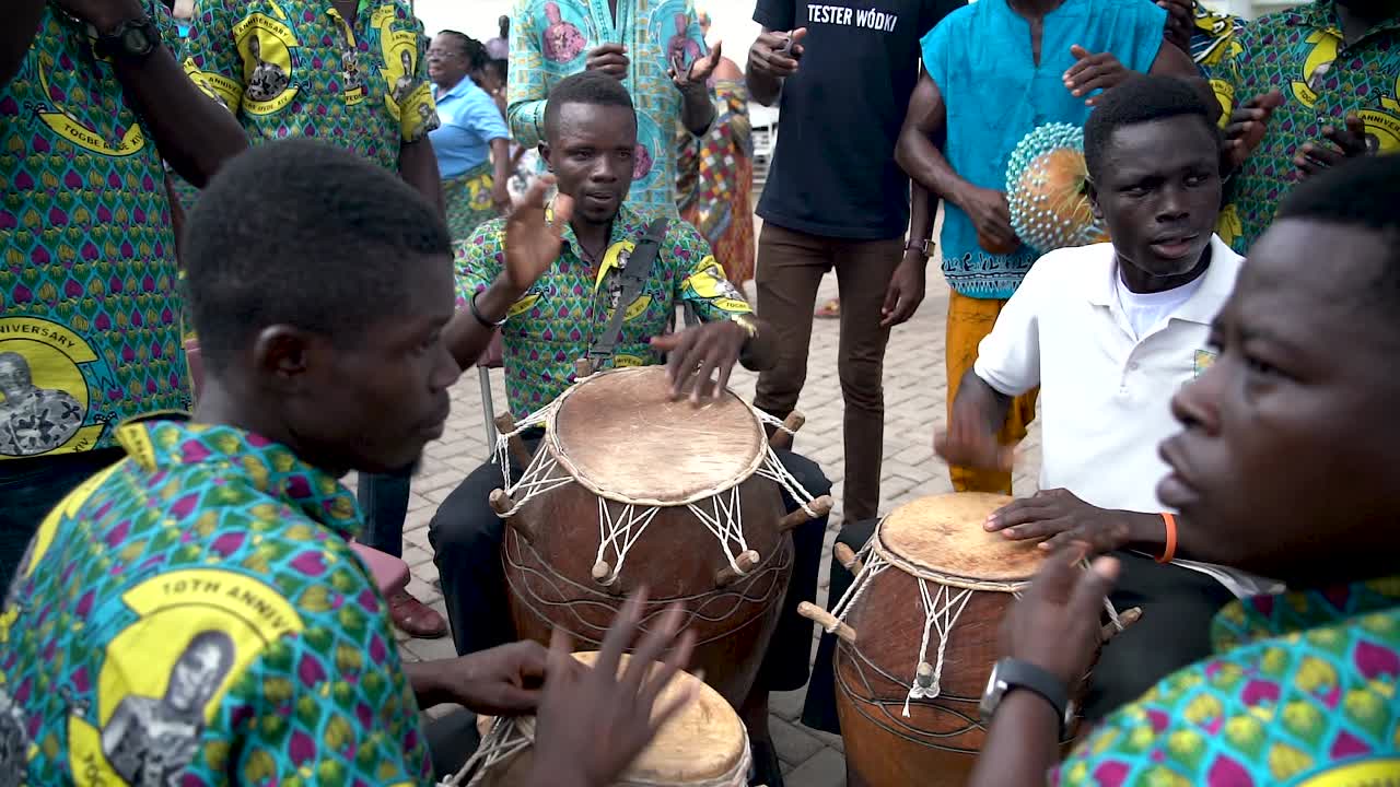 A close up slow motion shot shows a group of drummers pounding their drums for the Yam Festival in Ho, Ghana, West Africa.