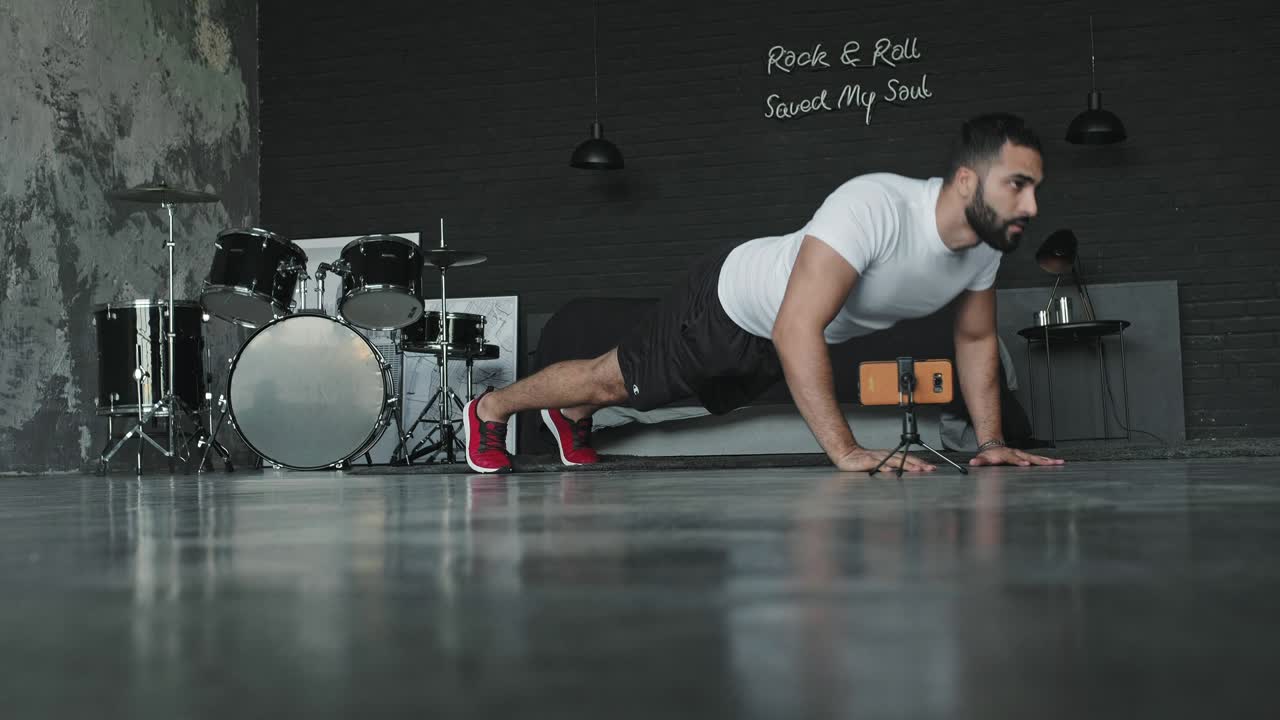 joven haciendo ejercicios en el estudio de música y lo dispara en el teléfono.