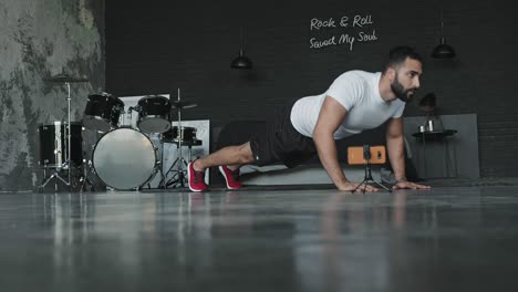 young man doing exercises in music studio and shoots it on the phone.