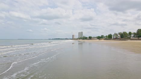 serene beach scene with ocean waves and coastal buildings