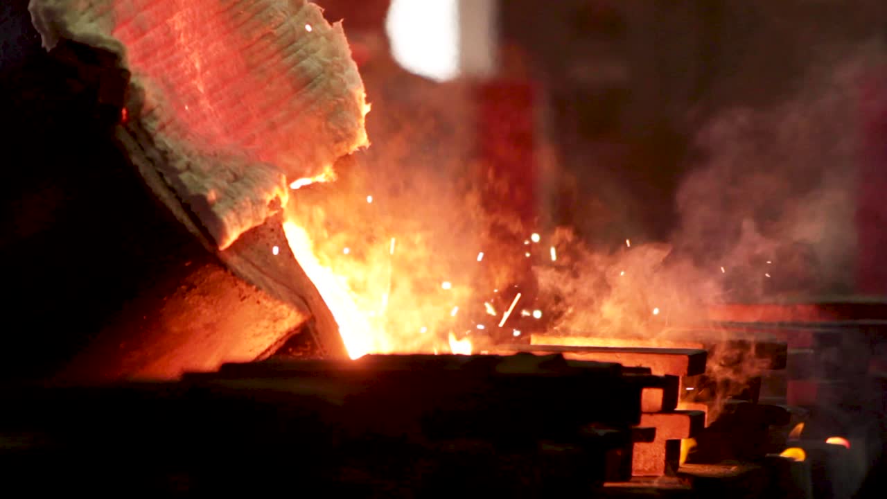 Molten metal being poured from hopper to cast at a foundry