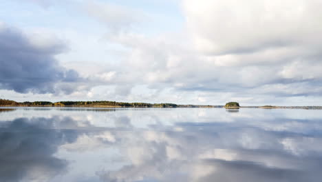 bandeja de agua del lago que refleja el cielo nublado y las islas boscosas distantes