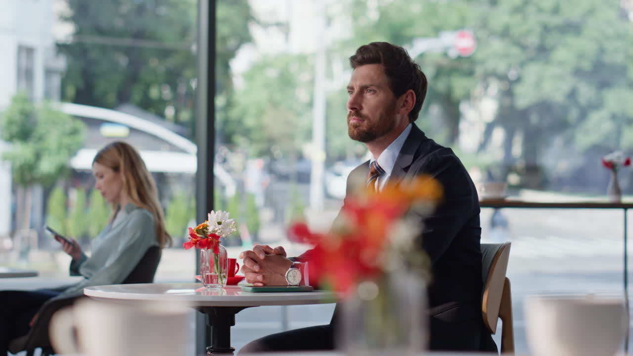 Serious businessman checking time at hand watch sitting cafe. Man waiting