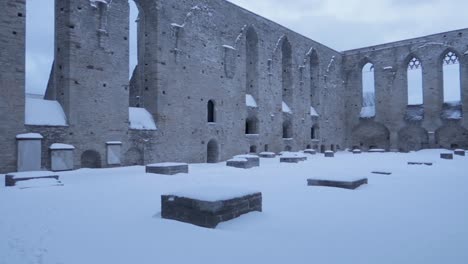 old covent in ruins with stone walls and snow covering the historical structure