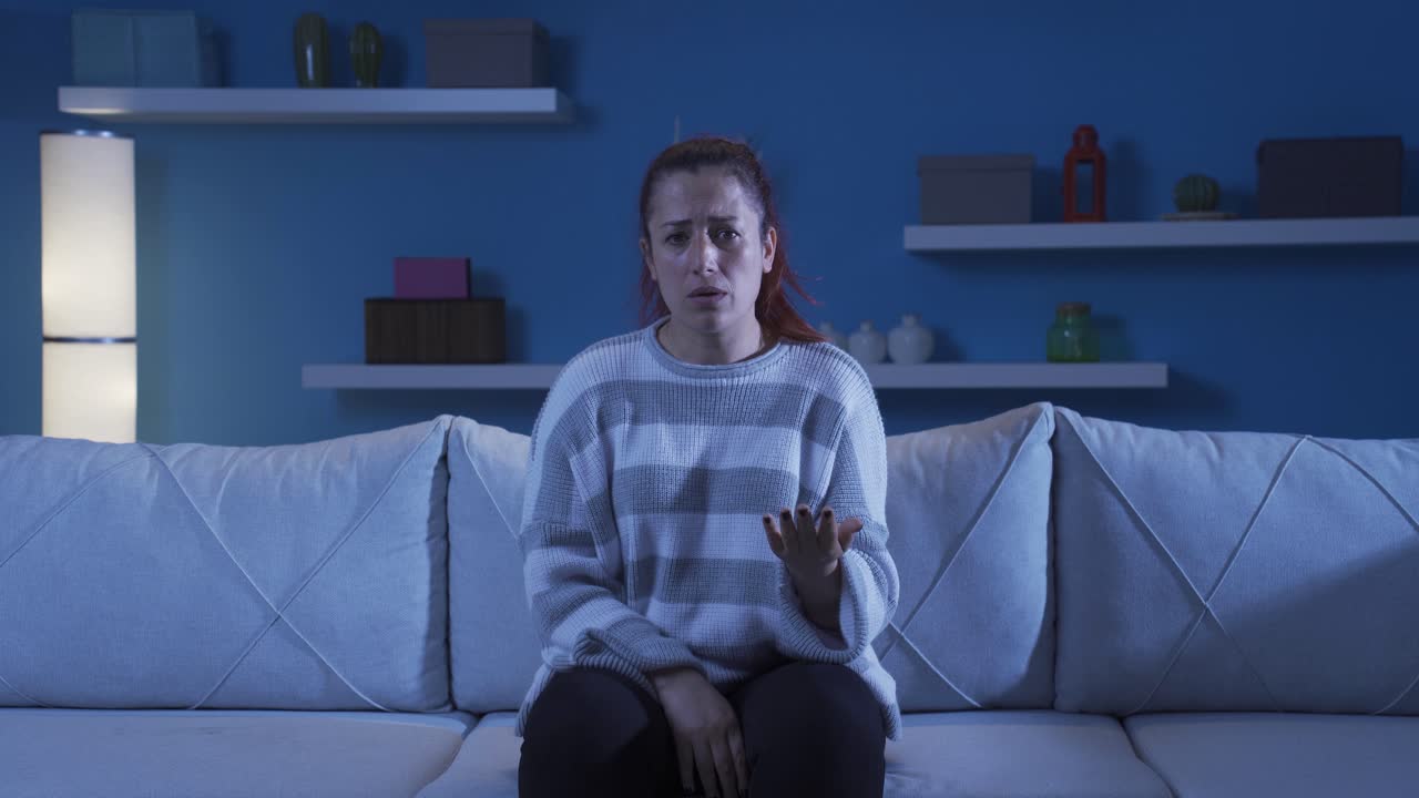 Depressed woman talking to camera.