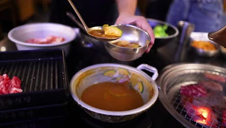 person ladling soup into a bowl