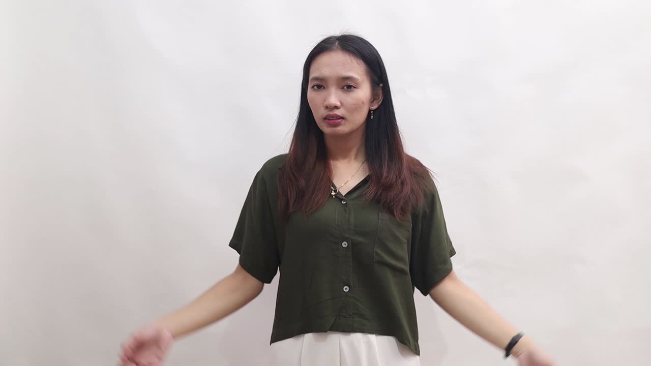young asian woman shows an expression of boredom and disapproval. Isolated on white background in studio.