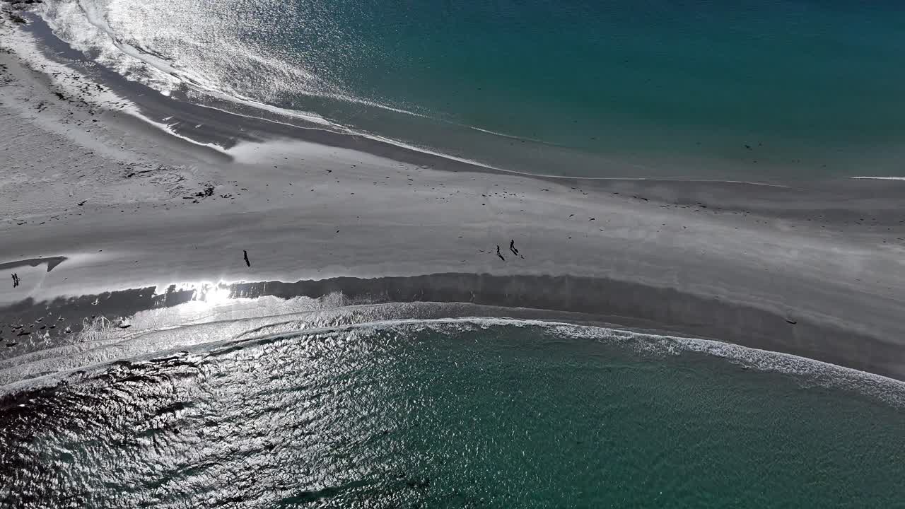 Tourists walking across sandbar of Diamond Island towards beach, aerial tilting shot