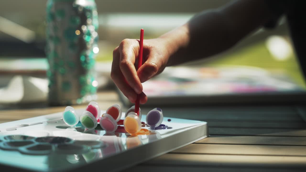 페인트에 붓을 담그고 있는 어린 소녀의 클로즈업