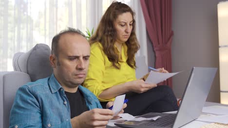 al calcular el presupuesto de la casa, el marido y la mujer miran las facturas.