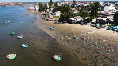 pescador caminando en una playa vietnamita muy contaminada cerca del área del resort a la orilla en un día soleado en vietnam