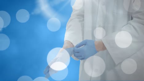 Animation-of-light-spots-over-caucasian-male-doctor-wearing-medical-gloves