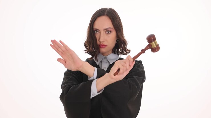Un giudice donna con un martelletto che incrocia le braccia a formare una X