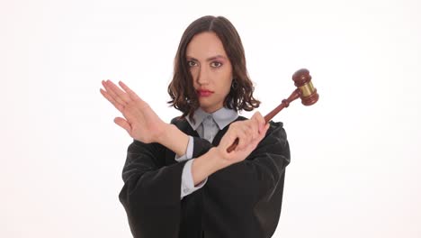 a female judge with a gavel making an x with her arms