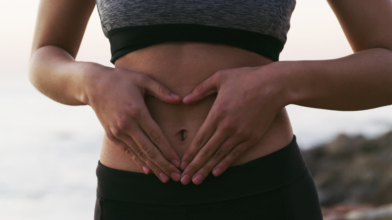 una mujer joven haciendo una forma de corazón con sus manos