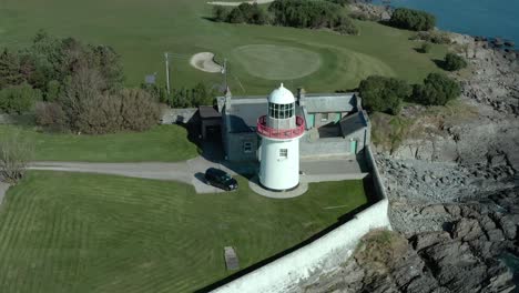 Toma-De-órbita-Aérea-Del-Faro-Durante-Un-Día-Tranquilo-Y-Soleado,-Gran-Angular