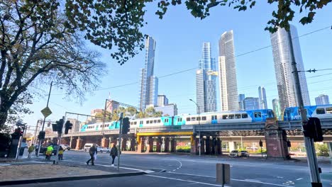 train crossing cityscape with pedestrians and skyscrapers