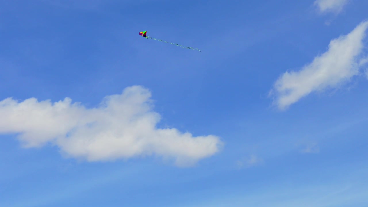 Una vista aerea 4K cattura un aquilone colorato solitario che si libra nell'aria. Il movimento fluido del drone offre uno sfondo naturale dinamico e minimalista per racconti di viaggio e della comunità.