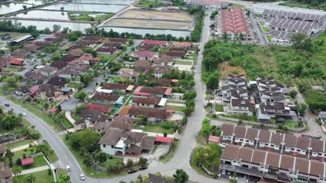 Drone-flying-around-Venice-of-Perak,-featuring-wide-array-of-residential-buildings-in-the-neighborhood-along-river-of-Dinding-and-aquaculture-facility-shrimp-rearing-pond-in-the-distance
