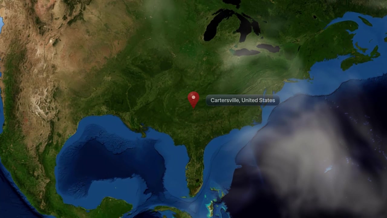 Satellite camera zooms from deep space orbit into Cartersville, Georgia, pinpointing its geographic location. Includes NASA public domain imagery.