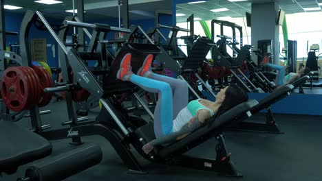 woman doing leg press exercise in gym