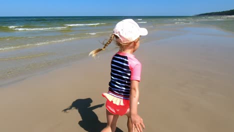 little girl running on sandy beach