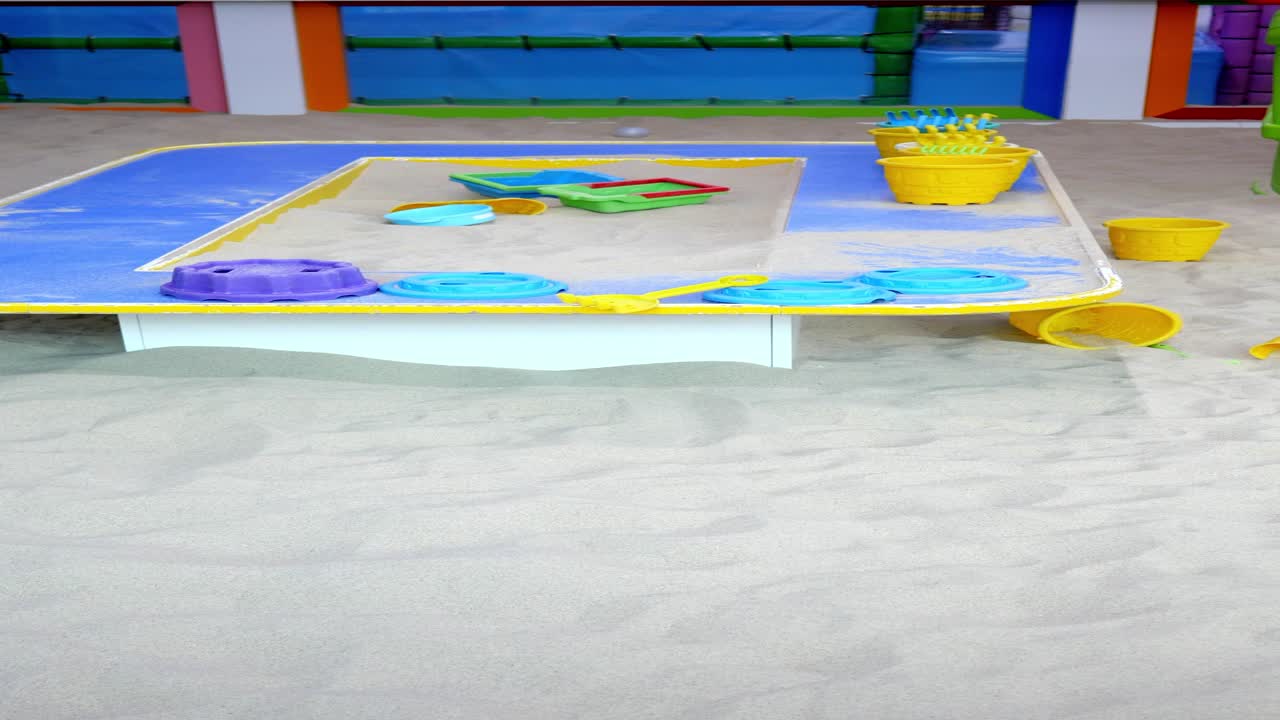 juguetes de arena coloridos en una caja de arena