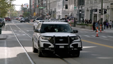 detroit police car driving down woodward avenue in detroit, michigan.