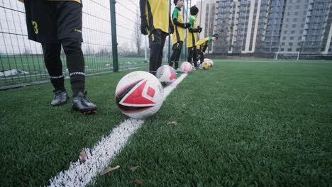 a children's football team trains at the stadium under the guidance of a coach. kids in sports uniforms practice ball exercises, improve technique, and develop teamwork on the green field