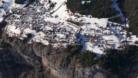 Vista-Aérea-De-La-Pequeña-Aldea-Suiza-Cubierta-De-Nieve-Murren