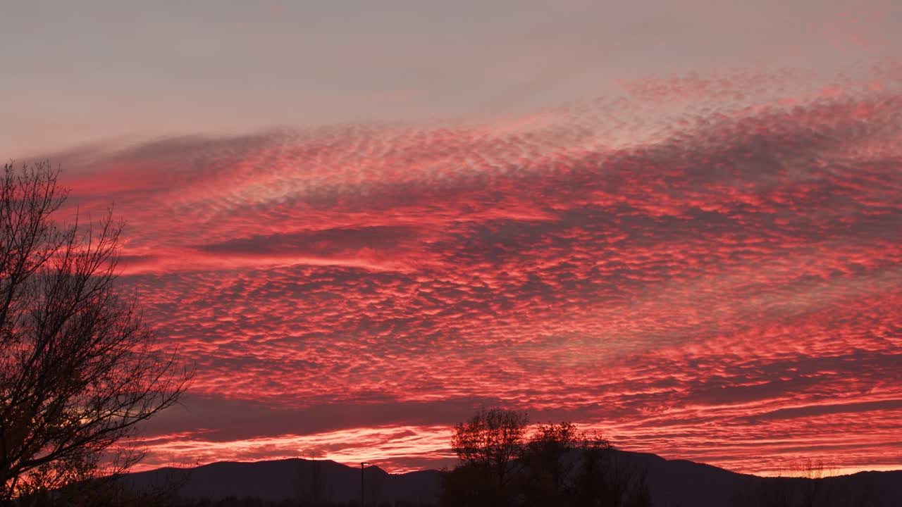 실루엣 언덕 위의 햇빛에 의해 붉은 색에서 타는 구름과 함께 서사시적인 일몰