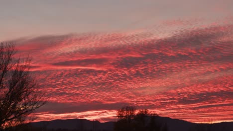 Epischer-Sonnenuntergang-Mit-Wolken,-Die-Durch-Sonnenlicht-Aus-Roter-Farbe-über-Dem-Silhouettenhügel-Brennen