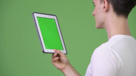 profile view of young handsome man using digital tablet