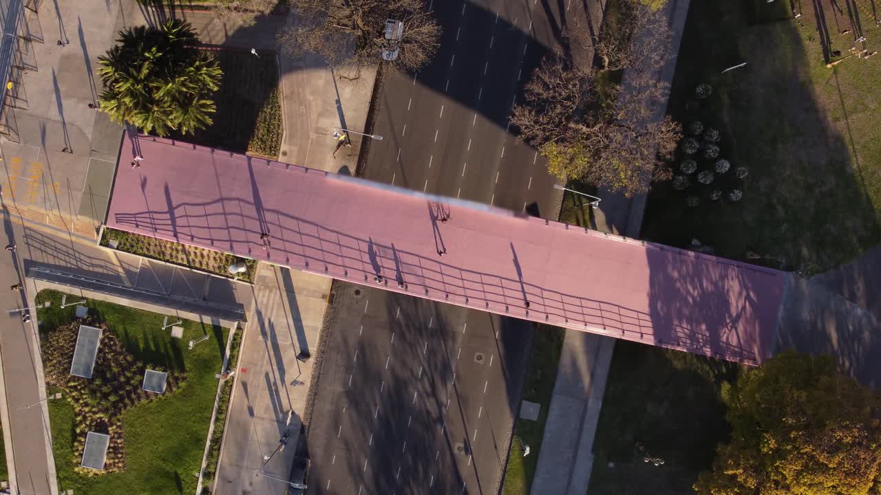 번잡한 고속도로를 가로지르는 공중 횡단 보행자 다리를 보여주는 공중 하향식 보기