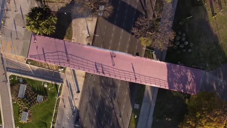 aerial top down view showing public crossing overhead pedestrian bridge over busy highway