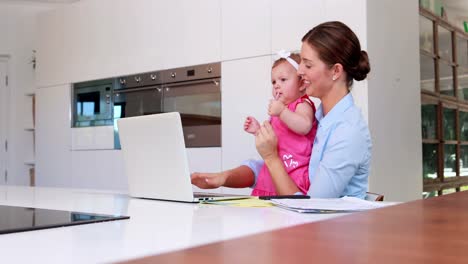 mujer de negocios con su bebé usando una computadora portátil